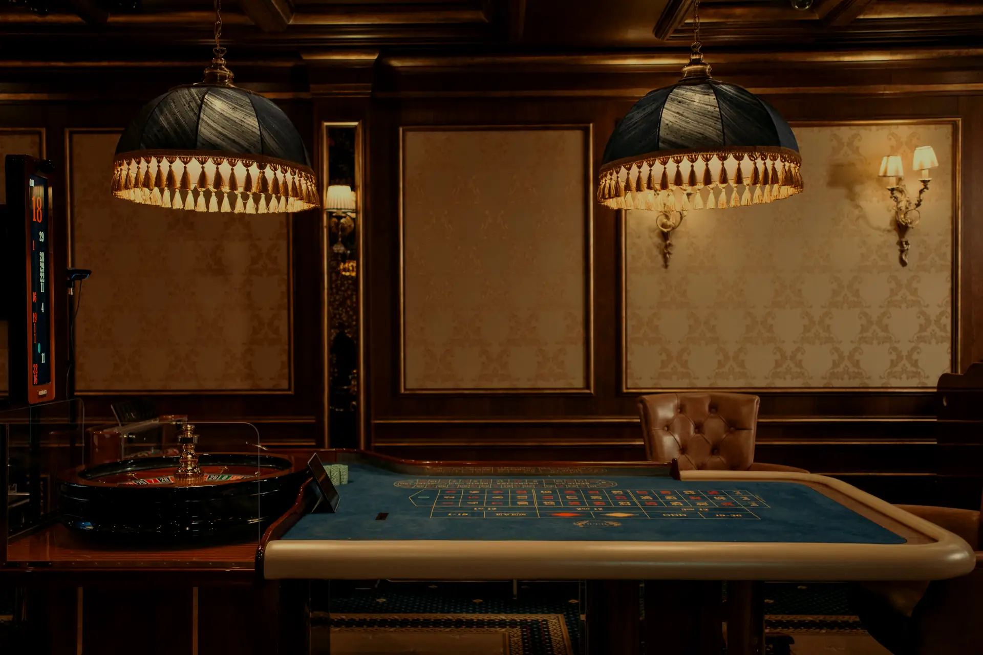 A private casino lounge with a roulette table under warm pendant lamps